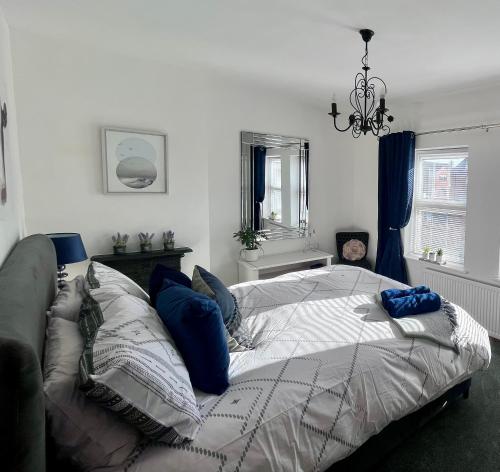 a bedroom with a bed with blue pillows on it at Village Escape in Messingham