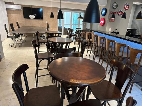 グアルジャにあるCondominio Club, Vista para o mar, Churrasqueiraのレストラン内のダイニングルーム(テーブル、椅子付)