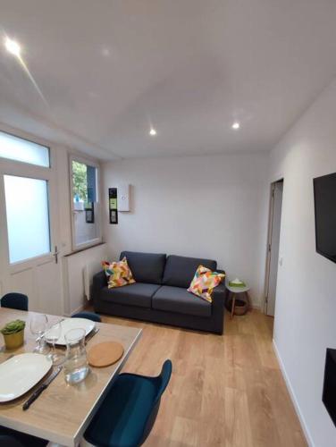 un salon avec un canapé et une table dans l'établissement La petite bascule, à Orléans