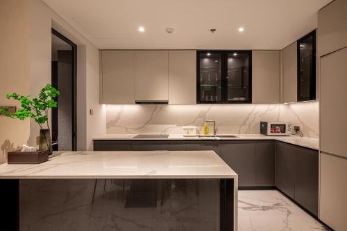 a kitchen with white cabinets and a potted plant at Metropole Thu Thiem Condo Apartment in Ho Chi Minh City