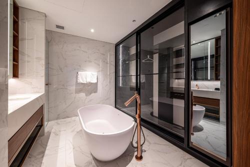 a bathroom with a tub and a sink and a toilet at Metropole Thu Thiem Condo Apartment in Ho Chi Minh City