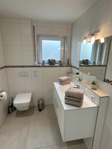 a white bathroom with a sink and a toilet at 2 Zimmer Traum mit Terrasse am Kocher Jagst Radweg nähe Heilbronn in Bad Friedrichshall