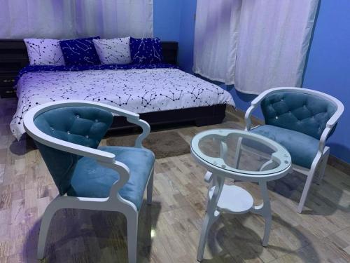 1 dormitorio con 1 cama, 2 sillas y mesa en Family & Friends Apartments, en Miocho
