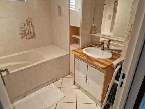 a bathroom with a tub and a sink and a bath tub at Appartement motte giron 2 personnes in Dijon