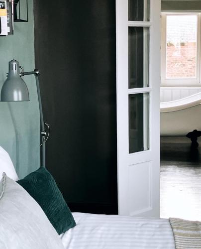 a bedroom with a bed and a bathroom with a tub at Domus Portus in Dendermonde