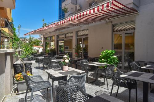 an outdoor patio with tables and chairs at Hotel La mer in Budva