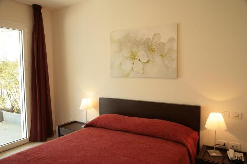 a bedroom with a red bed and a window at Residence San Paolo in Lido di Savio