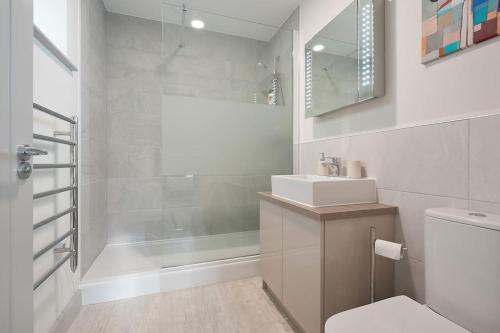 een badkamer met een toilet, een wastafel en een douche bij Spacious 4 bed home with gym and tennis court in South Carlton