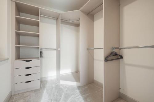 a walk in closet with white walls and shelves at Spacious 4 bed home with gym and tennis court in Lincoln