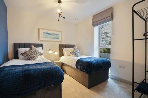 a bedroom with two beds and a window at Spacious 4 bed home with gym and tennis court in Lincoln
