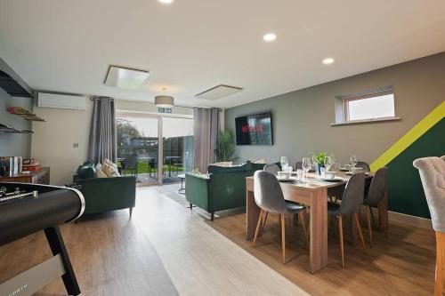 a dining room and living room with a table and chairs at Spacious 4 bed home with gym and tennis court in Lincoln