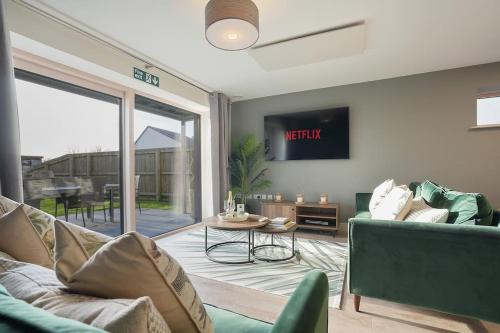 a living room with a couch and a table at Spacious 4 bed home with gym and tennis court in Lincoln