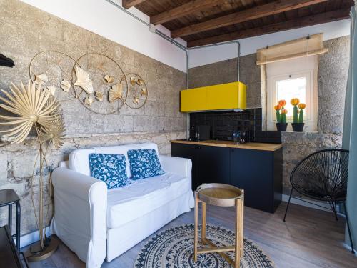 a living room with a white couch and a kitchen at Casa Sabai in Las Palmas de Gran Canaria