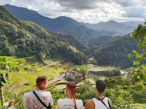 three people standing on a hill looking at a valley at BANAUE EVERGREEN HOSTEL AND RESTAURANT in Banaue