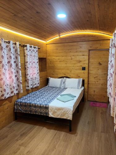 a bedroom with a bed in a wooden room at ชายเขาโฮมสเตย์ in Kanchanaburi