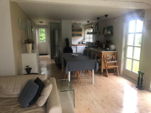 sala de estar con sofá y mesa en Hyggeligt idyllisk hus, en Rønde