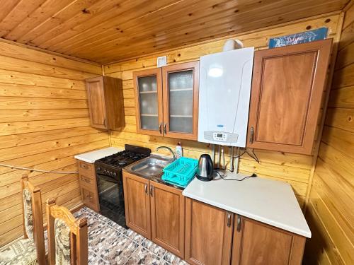 a kitchen with a stove and cabinets in a cabin at Карпатська ніч in Plav'ya