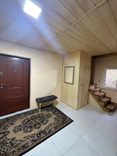 a room with a door and a rug and a bench at Карпатська ніч in Plav'ya