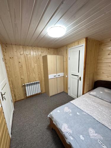 a bedroom with a bed in a wooden room at Карпатська ніч in Plav'ya