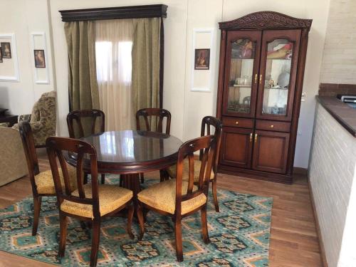a dining room with a table and chairs and a cabinet at Beautiful private villa Magawhish in Hurghada