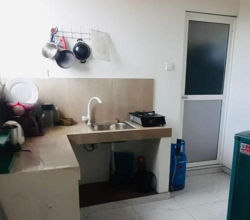 a kitchen with a sink and a counter with pots and pans at mahida gust house in Weligama