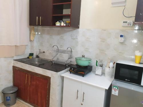 una cucina con lavandino e piano di lavoro di Elegant studio stays a Kitengela 