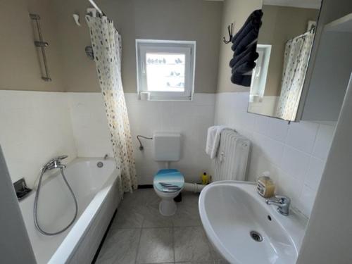 ein Badezimmer mit einer Badewanne, einem WC und einem Waschbecken in der Unterkunft Roxy Ferienwohnung in Rodenbach