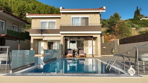 uma casa com piscina em frente a uma casa em Lila's villa maisonette with private pool em Nerotriviá