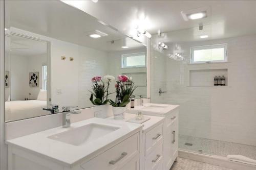 a white bathroom with a sink and a mirror at Shoreline Cottage in Santa Barbara