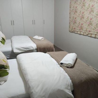 a room with two beds with towels on them at KarMichael Farm in Himeville