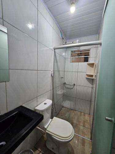 a small bathroom with a toilet and a shower at Arahra Hotel in Aparecida de Goiania