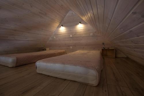 a bedroom with two beds in a room with wooden walls at Apartament Agroturystyka Koniec Świata in Lesna