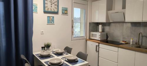 a kitchen with a table with chairs and a clock on the wall at Costa del Hel in Hel