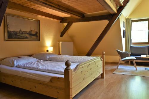 um quarto com uma cama e uma cadeira num quarto em Hotel-Restaurant Zum Goldenen Stern em Großalmerode