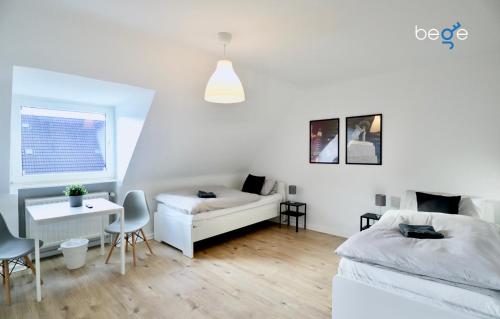 a white room with a bed and a desk and a couch at BEGE APARTMENTS Corporate Stay in Gelsenkirchen