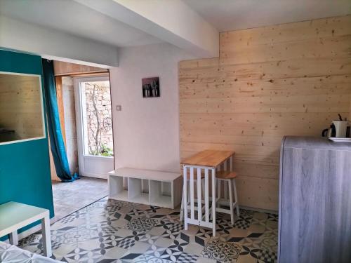 Habitación con paredes de madera, mesa y ventana. en Côte Dors en Corpeau