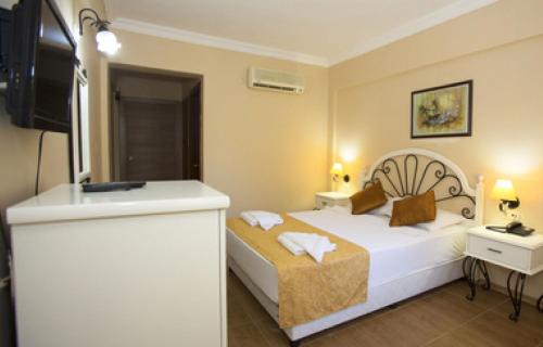 オルデニズにあるZehra Hotel - Halal All Inclusiveのベッドとシンク付きのホテルルーム