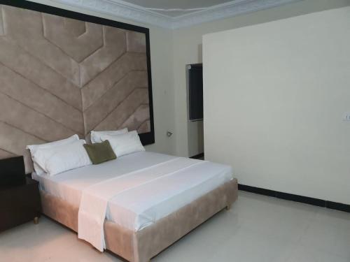 a bedroom with a large bed with a large headboard at Shelton House in Karachi