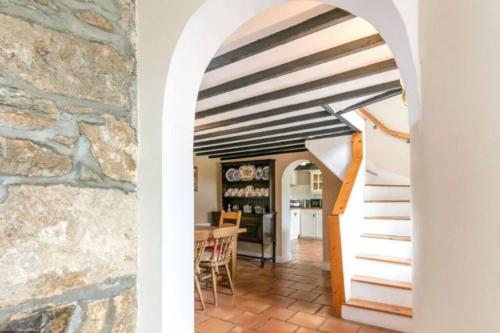 uma escada numa casa com uma parede de pedra em Sweet Lamb Farmhouse em New Ross