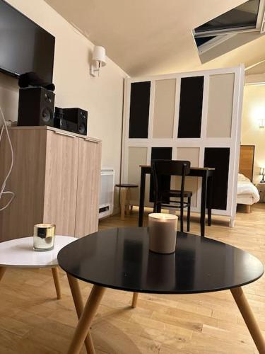 un salon avec une table et des chaises noires dans l'établissement Charm’Studio Cosy Suréquipé, à Colombes