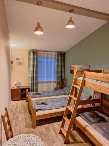 a room with two bunk beds and a table at Viesu nams ADLERI in Saldus