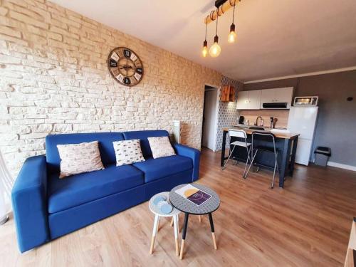 sala de estar con sofá azul y pared de ladrillo en Le Combo Parfait entre Mer et Nature, en Villers-sur-Mer