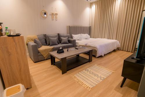 a living room with a couch and a bed at استديو مودرن بمدخل ذاتي بجانب البوليڤارد in Riyadh