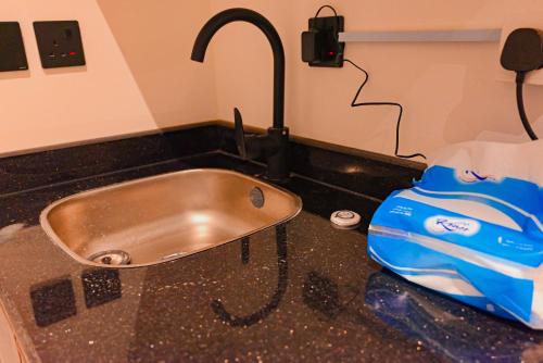 a kitchen sink with a faucet and a blue bag at استديو مودرن بمدخل ذاتي بجانب البوليڤارد in Riyadh