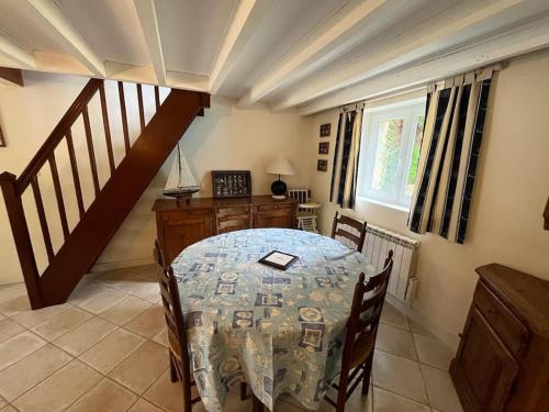 une salle à manger avec une table et un escalier dans l'établissement Maison à 100 m de la plage et proche du centre, à Jullouville