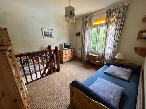 - une chambre avec un lit bleu et un escalier dans l'établissement Maison à 100 m de la plage et proche du centre, à Jullouville