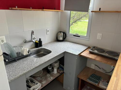 a small kitchen with a sink and a window at Complejo Las Palmeras in Colonia del Sacramento