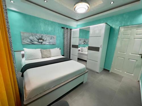 una camera con letto e parete blu di Precious Palace a Accra