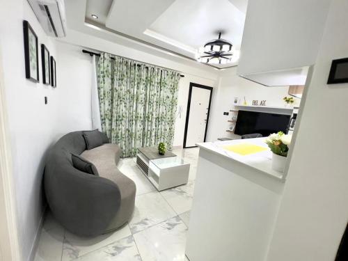 un soggiorno con divano grigio e una cucina di Precious Palace a Accra
