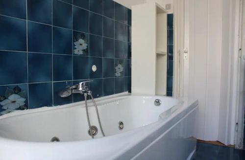 a bath tub in a bathroom with blue tiles at Appartamento 5 stelle in Piazza Asti - Re di Roma - in Rome